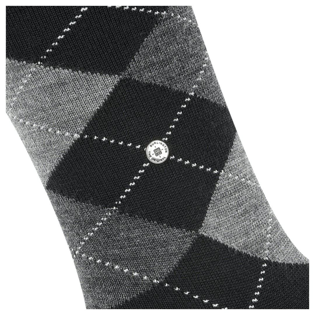 Argyle damessokken close-up: zwart-grijze ruiten en rond label in de middenzone