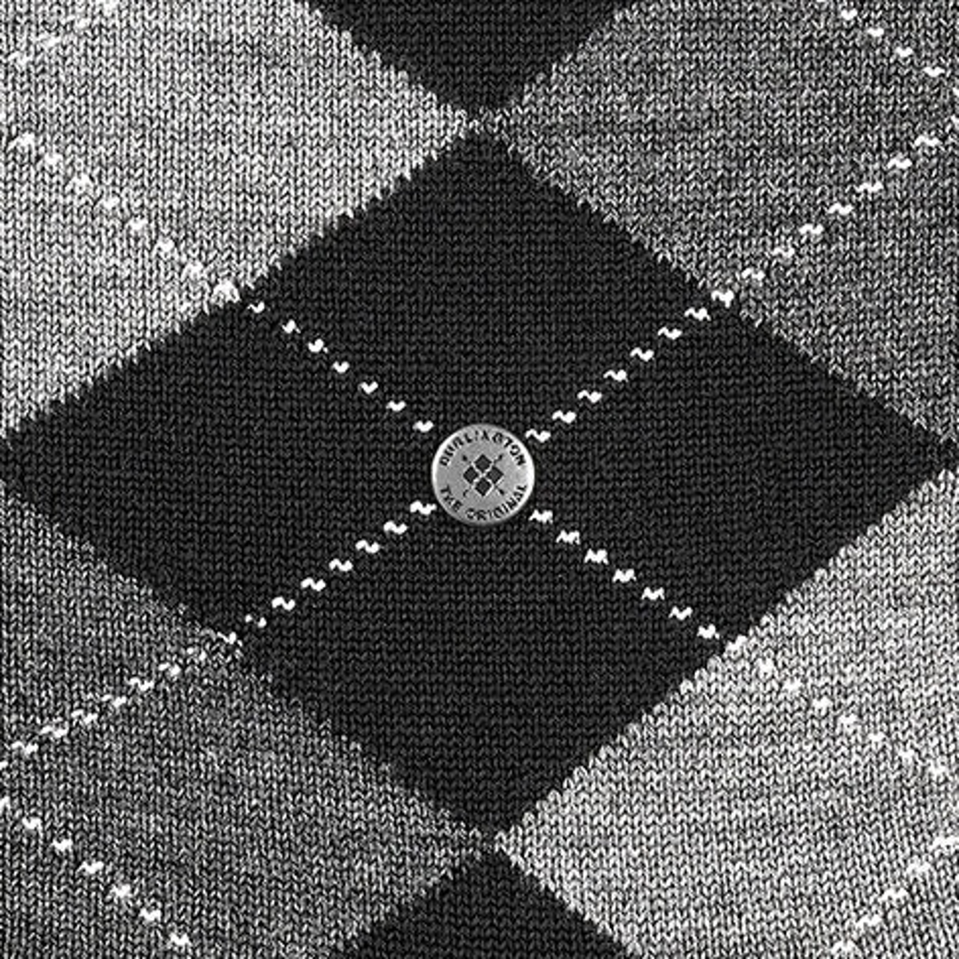 Close-up argyle sok: zwart midden met grijze ruiten en rond embleemlabel