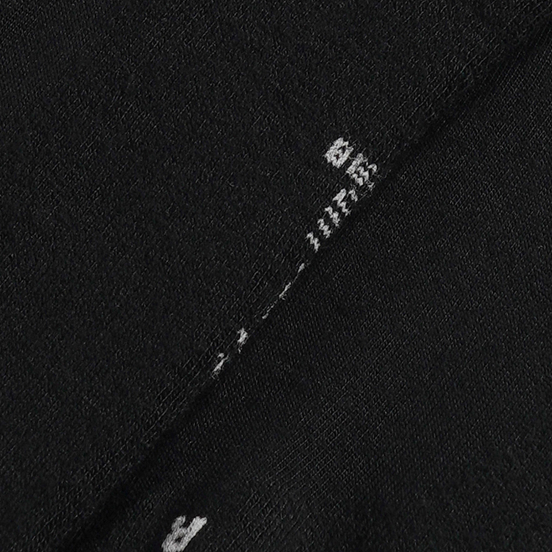 Zwarte sneakersok, close-up van witte borduurlogo op de boord