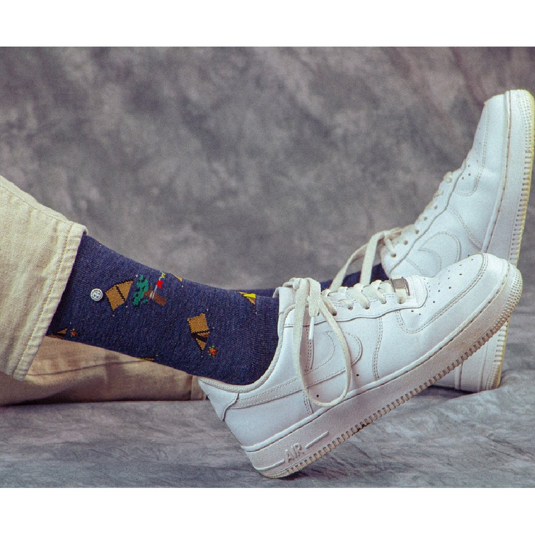 Campingprint marine sokken onder witte sneakers, voeten in beeld