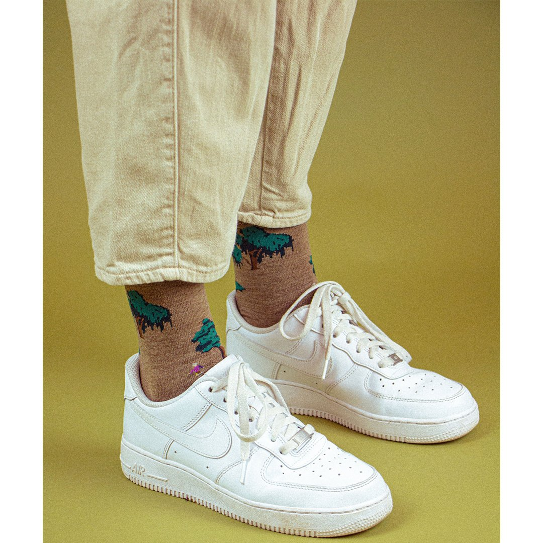 Bosprint sokken in kaki bij witte sneakers, zichtbare voetboord.