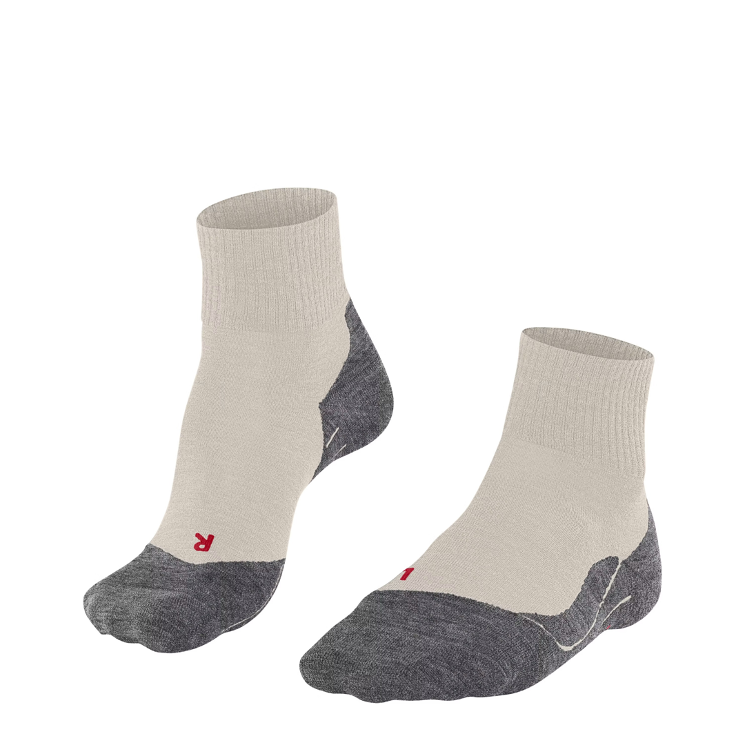 Korte wandelsokken met crème boord en donkergrijze hiel en teen, rode FALKE-logo’s.